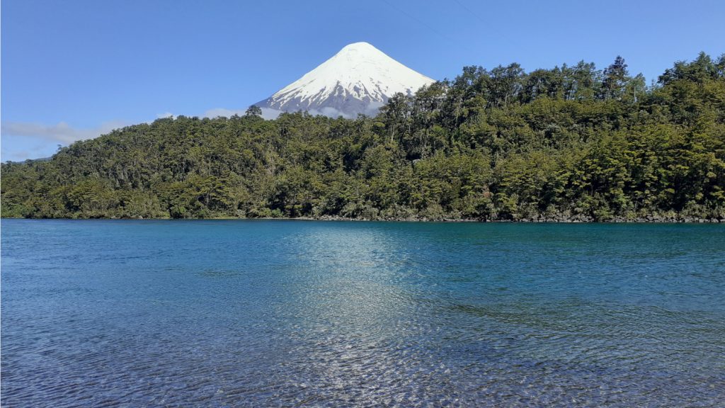 Vue du sommet enneigé du volcan Osorno surplombant la rivière Petrohué au Chili