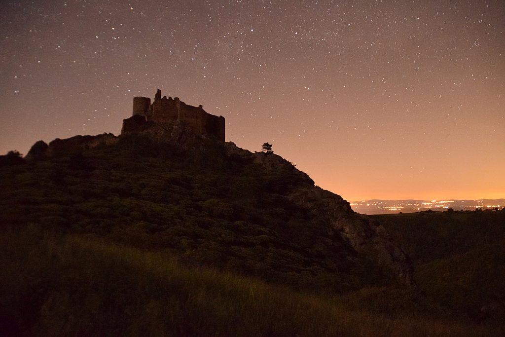 Le Château de Sail sous Couzan de nuit avec la plaine du Forez en fond